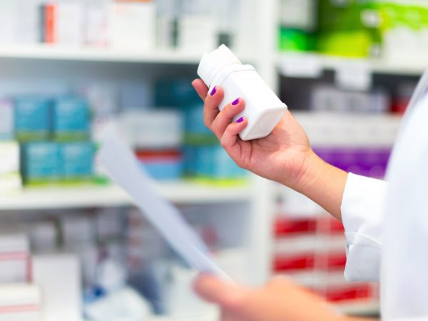 Woman customer in the pharmacy taking a medicine box Woman customer in the pharmacy taking a medicine box